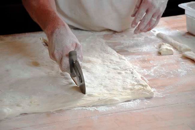 German baker Thomas Kohnen cutting dough.